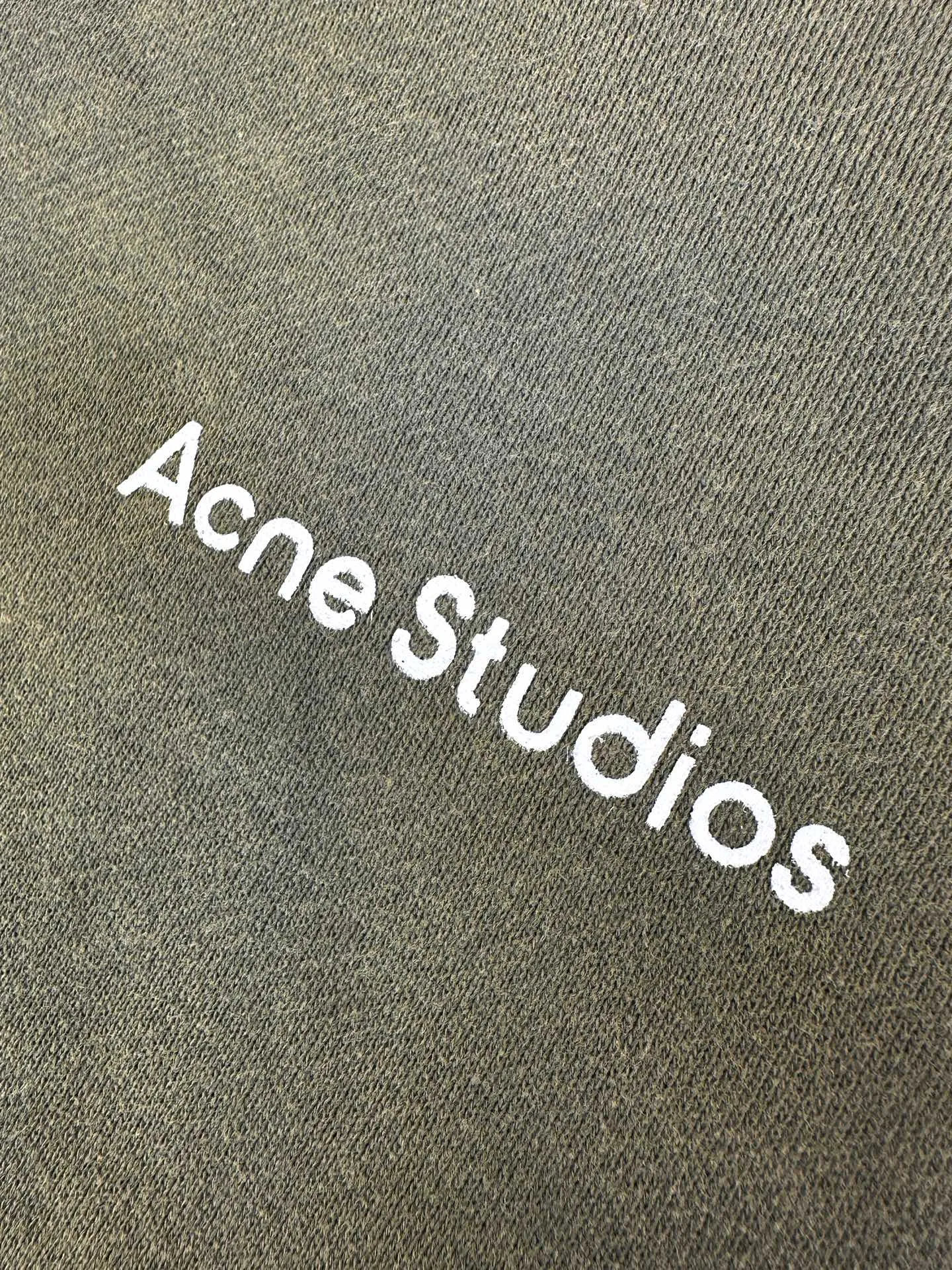 Acne Studi spray-painted distressed logo hooded jacket. Customized dusk-dyed acid-washed cloud-like fleece. Smooth drape. Soft and skin-friendly. Dressed in moss gray and green as a base. Water-washed and acid-washed soft fabric. Matte gray and green for a relaxed Retro street style. Raglan sleeves with full zipper and hooded silhouette. Acne Studios print on the left chest. Low-key and restrained without being ostentatious. Hand-made distressed repair texture in many places on the body. Retro traces simulated wear and repair, giving the garment a sense of narrative. Classic kangaroo pockets are practical and appropriate. Ribbed cuffs and hems lock the silhouette of the body. Integrate worn-out Retro aesthetics into daily life with the deconstructed ready-to-wear language. Interpret the relaxed high-end posture of the Scandinavian pioneers. Process 1: Adopt glue printing process. The chest printing has been revised three times with the film screen. Use glue liquid paint to print the pattern on the fabric. Bake the fabric to fix the printed pattern. Process 2: Use imported machine embroidery process. Use advanced computer control systems and precision mechanical components to achieve detailed patch work with high precision and smooth and delicate lines. Process 3: Gradient distressed spray process. By spraying dyes of different colors on the surface of the fabric, the clothes can show rich color changes under different lights and increase the visual layering. Process 4: Many parts of the body are worn by pure manual regular positioning and manual brush marks. Add texture and depth to the surface of the clothing to imitate the texture of natural wear. Process 5: The fabrics have been fermented and washed. Better hand feel, not easy to deform, not easy to shrink, not easy to fade, maintains long-term beauty. Accessories: Customized 1:1 Acne zipper. Customized 1:1 Acne trademark. Version: Loose version. Size: S M L XL. Style number: CC 7003.